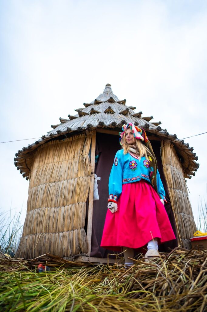 Sky in Peruvian clothing walking out of a hut