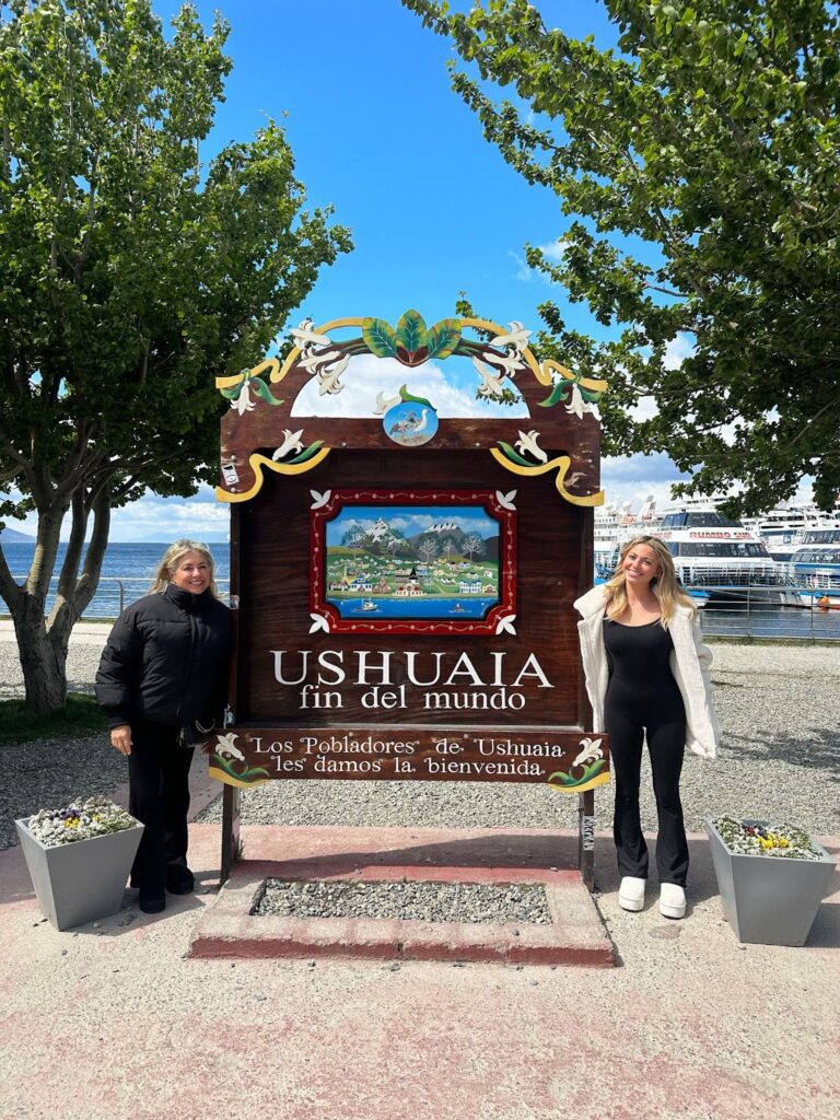 Sky and her mom next to an "Ushuaia: The End of the World" sign