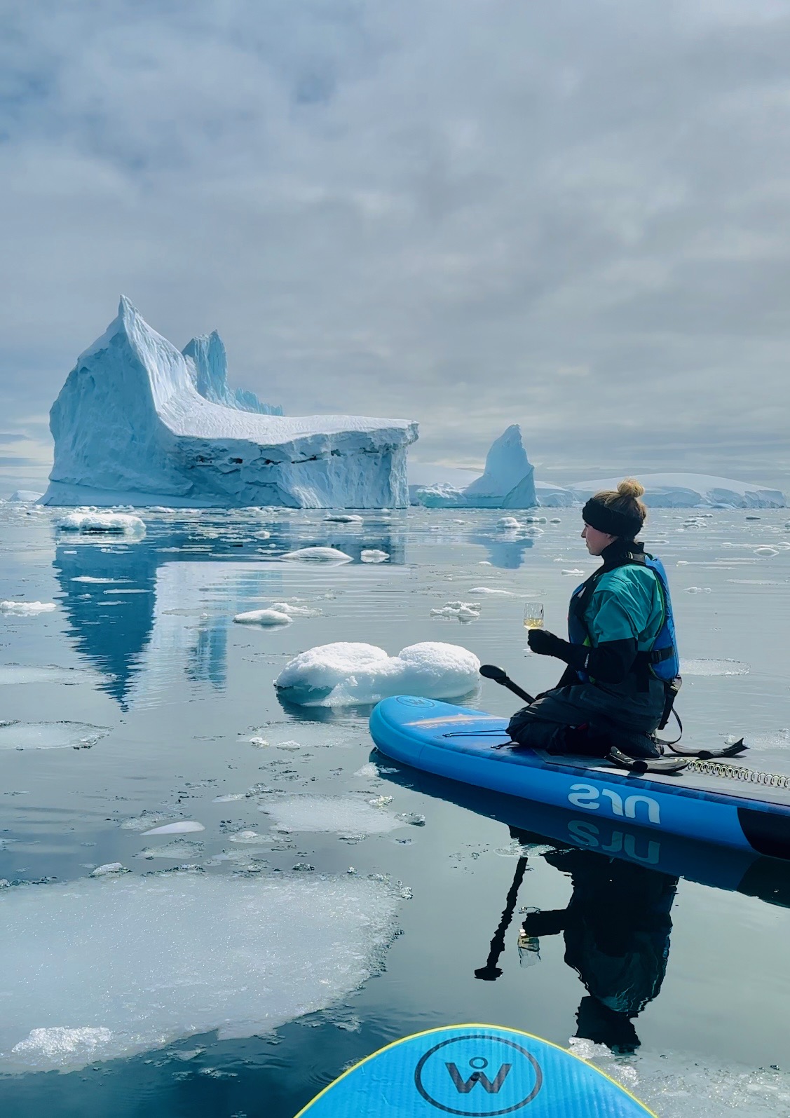 paddleboarding through ice in antarctica - with a glass of wine